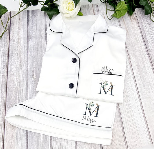 White satin feel pyjamas set with shorts and short sleeve shirt style top. Printed with initial on the breast pocket with name and the word bride over the initial.  