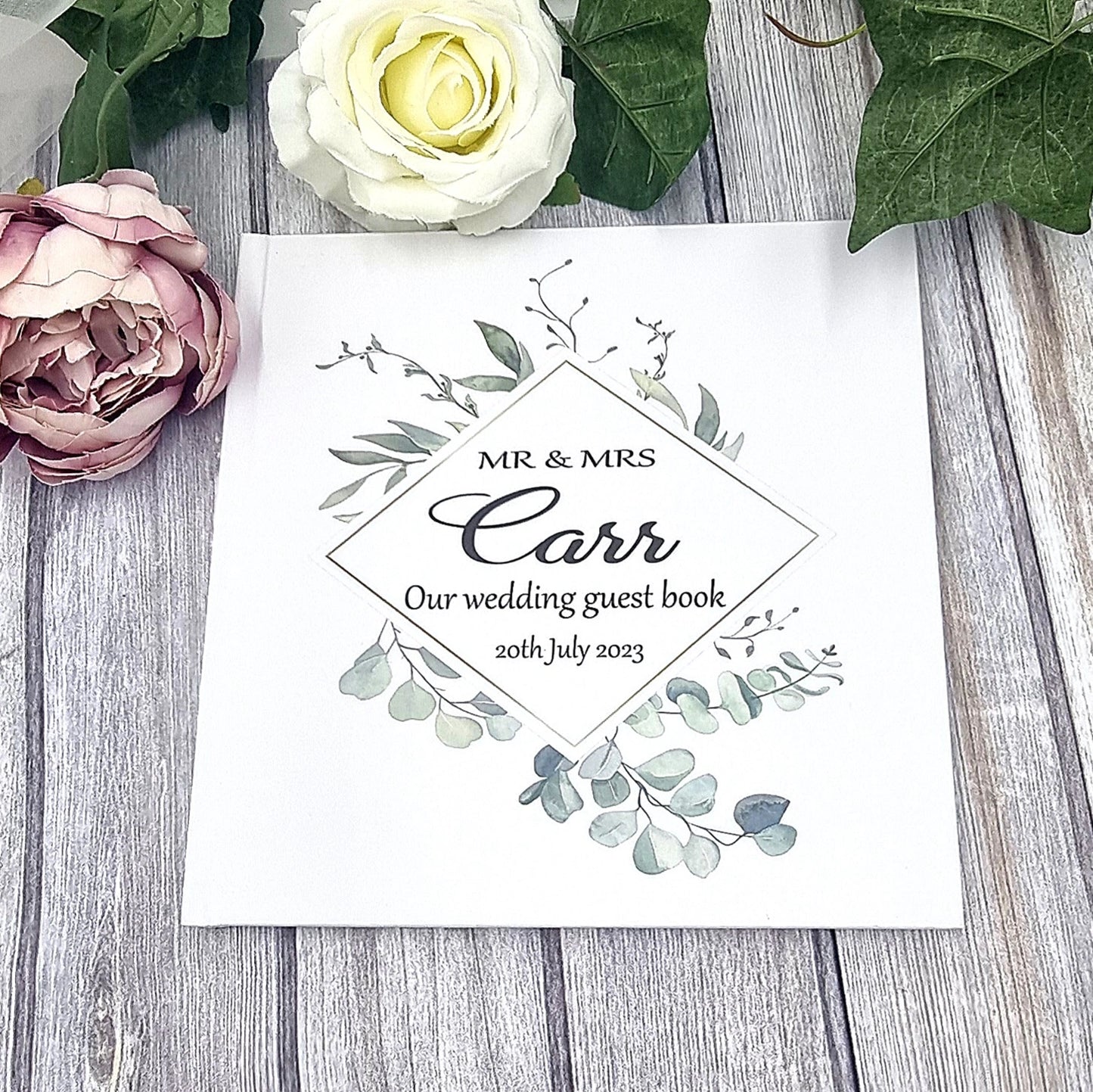 Beautiful personalised wedding guest book with eucalyptus wreath design and couples names and wedding date.