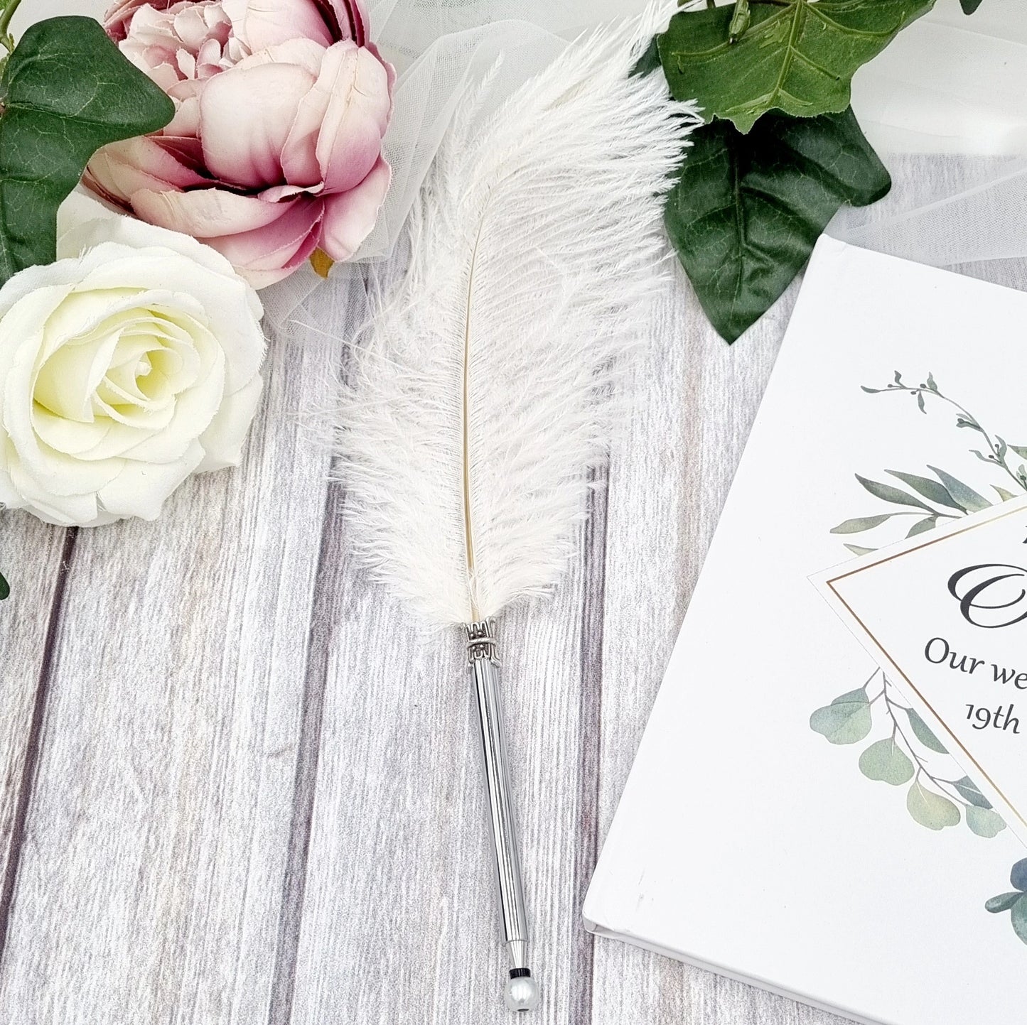 Beautiful white ostrich feather pen with blank ink for signing the register and guest book