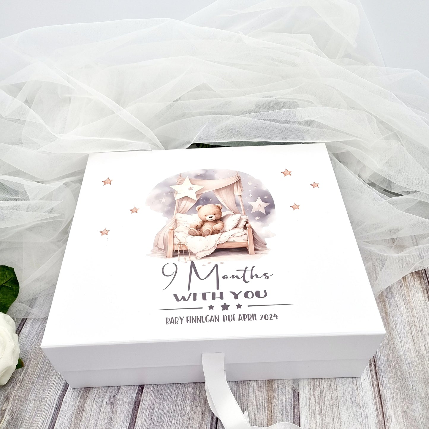 White gift box with design of teddy sitting on a bed with caption 9 months with you and the baby's details for baby shower.