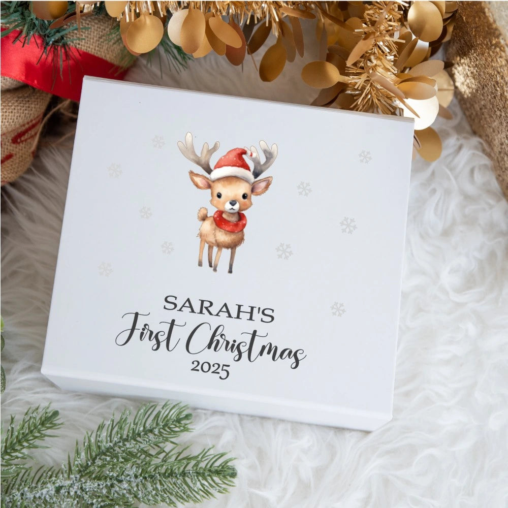 Personalised baby Christmas keepsake box featuring a cute reindeer wearing a Santa hat and scarf with snowflake accents; the lid reads “Sarah’s First Christmas 2025”.