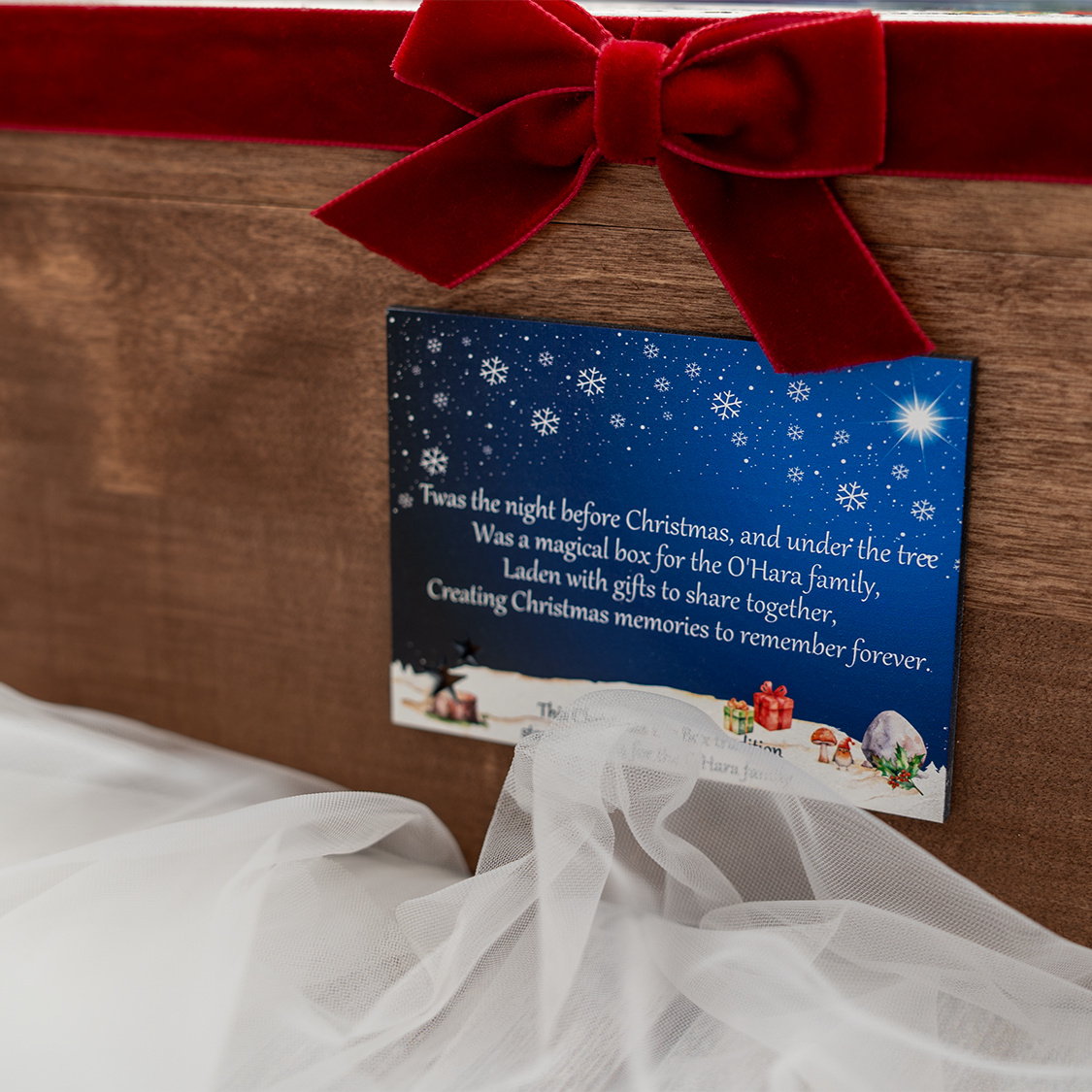 Luxury wooden Christmas Eve Box with custom illustrated lid and ribbon, surrounded by festive holiday décor – unique Christmas family tradition.