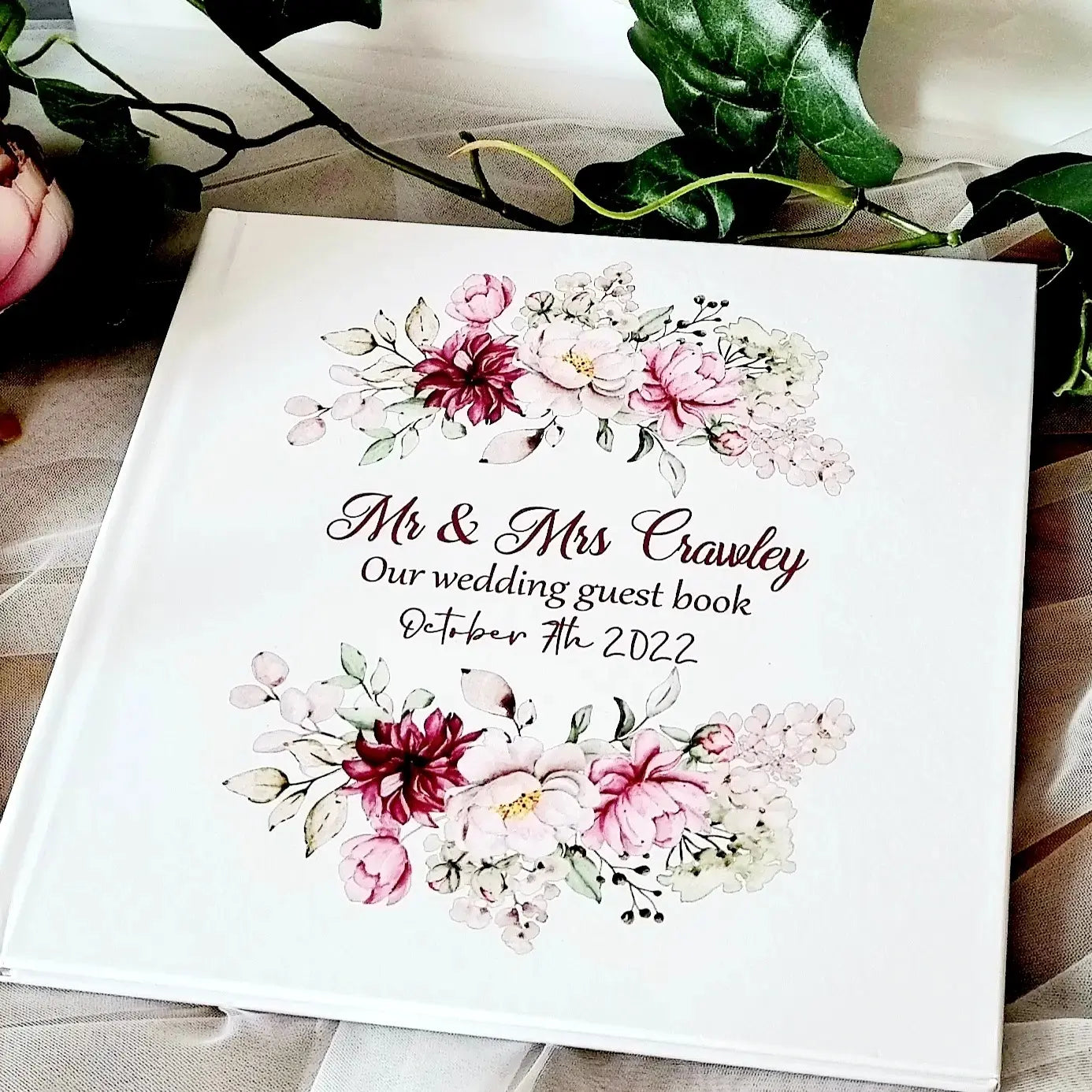 Personalised wedding guest book with pink and burgundy floral details with couples name and wedding date. 