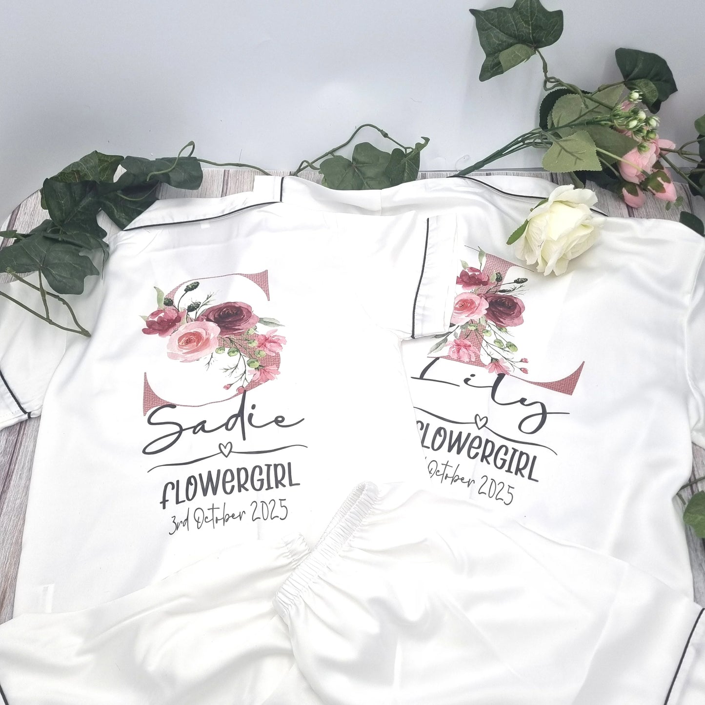 Matching personalised flowergirl pyjama sets with floral initial designs, custom printed with names and dates by HanaLee Studios in Co. Meath, Ireland.
