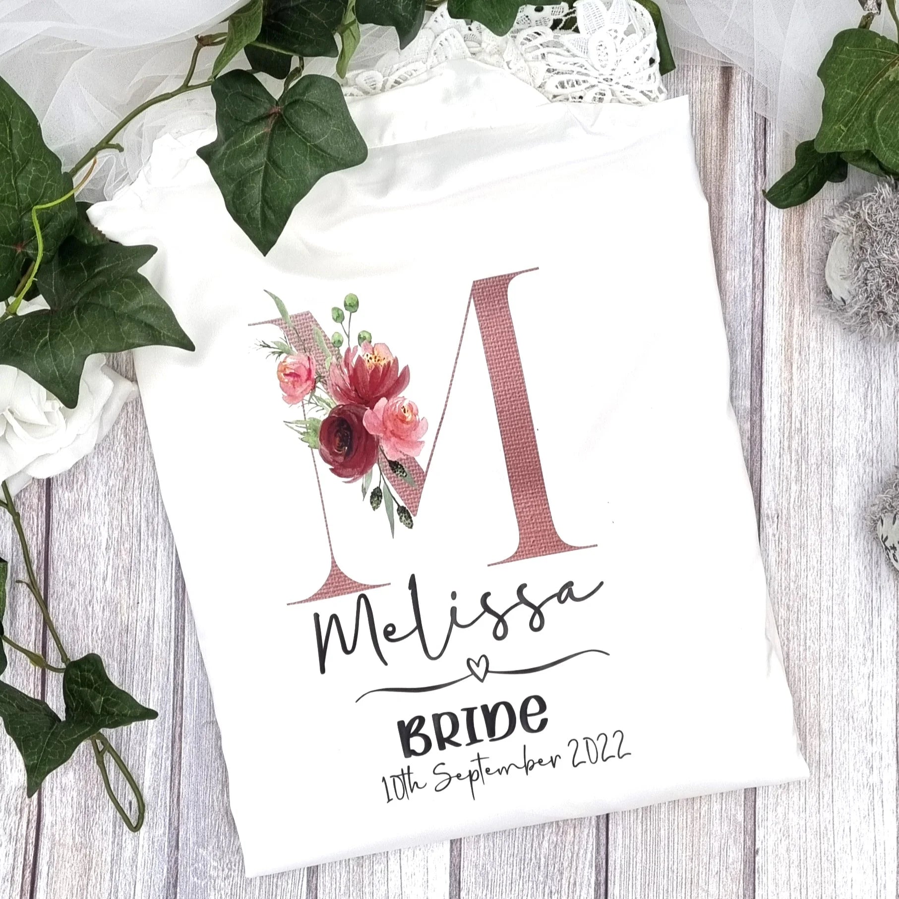 Personalised bride robe in white satin with floral initial “M” design and lace detailing – Irish designed and printed by HanaLee Studios.