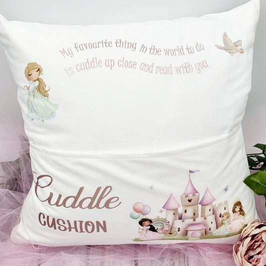 This is a white cushion with a pock at the front for children to put in a book. It is printed with a princess palace design on the front and  princess at the Top. The text reads - my favourite thing in the world to do is cuddle up close and read with you.