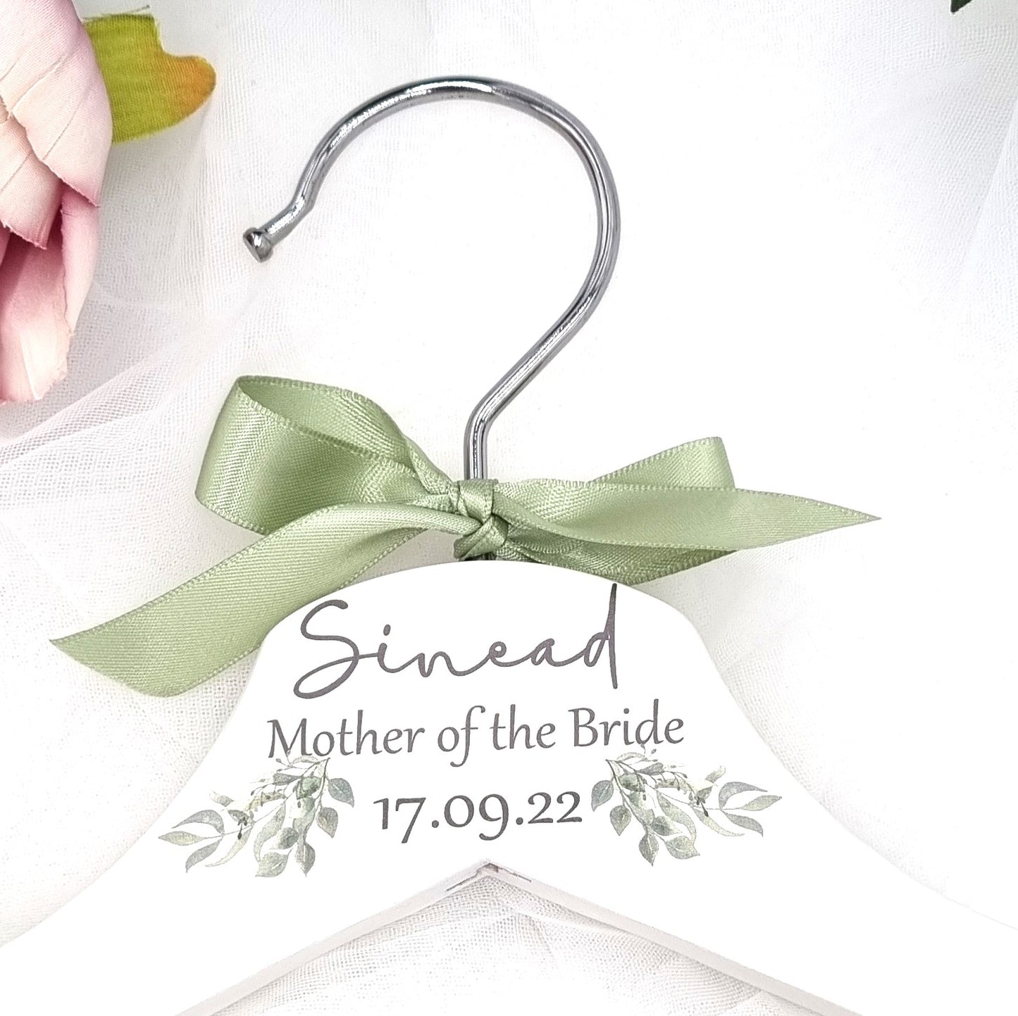 HanaLee's beautiful white wooden hanger with eucalyptus printed design and personalised with name title and date of the wedding. Each hanger is finished off with choice of ribbon colour