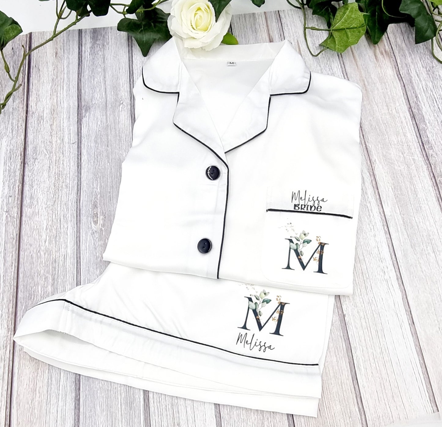 White satin feel pyjamas set with shorts and short sleeve shirt style top. Printed with initial on the breast pocket with name and the word bride over the initial.  