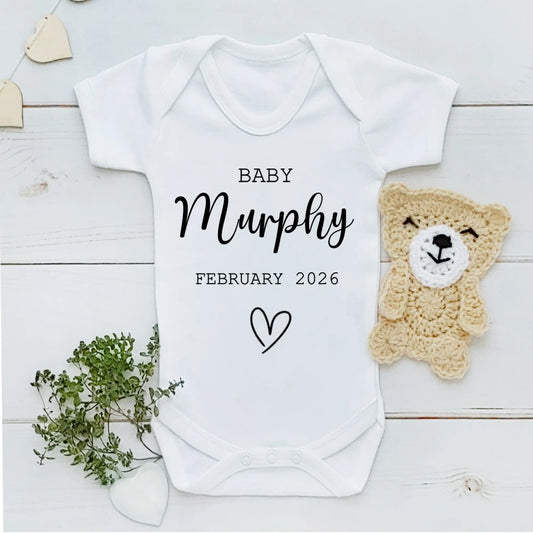 White cotton baby announcement vest personalised with custom text, perfect for pregnancy reveal, new baby gift or keepsake, handmade in Ireland.