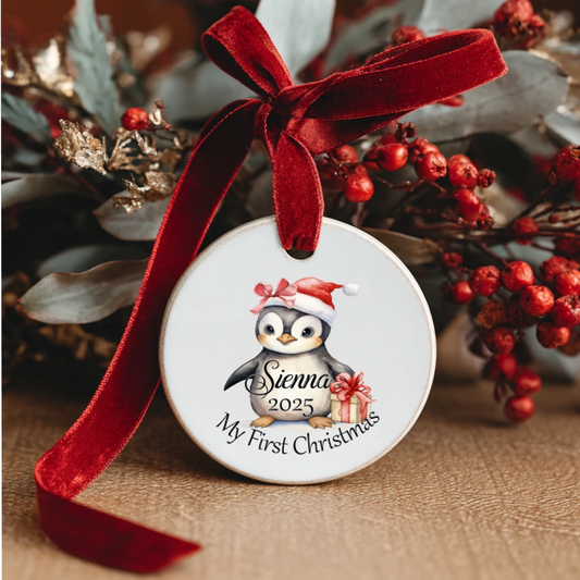 Ceramic christmas decoration with design of penguin in santa hat with baby's name and the year. 