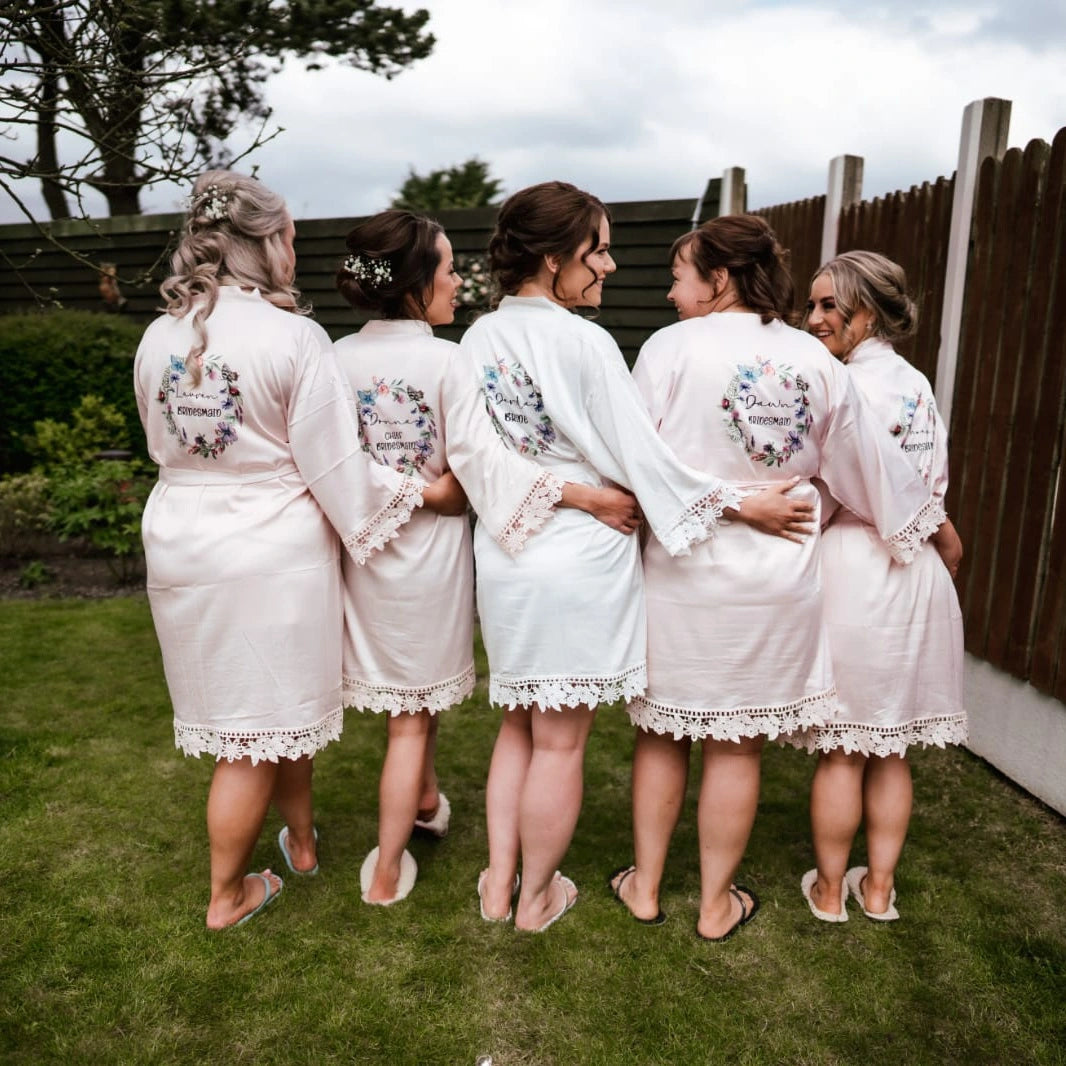 Bride and bridesmaids in matching personalised robes with lace trim, standing together outdoors before the wedding, robes printed by HanaLee Studios, Co. Meath, Ireland.