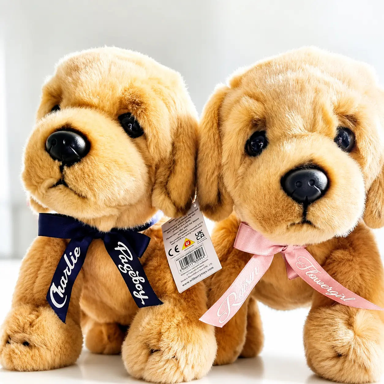 Personalised page boy and flower girl puppy keepsake with custom printed ribbon, photographed with elegant wedding décor and soft natural lighting.