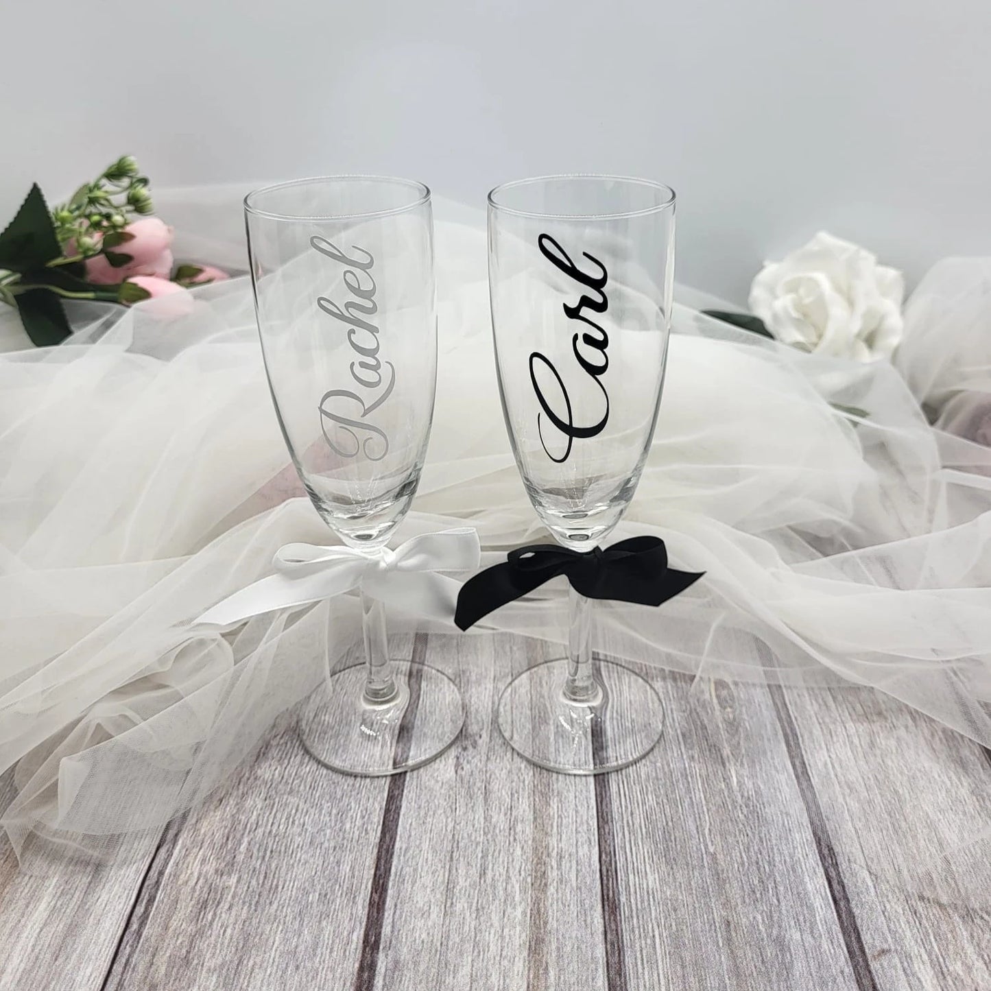 Elegant Irish-finished personalised wedding flutes displayed with floral background and tulle fabric.