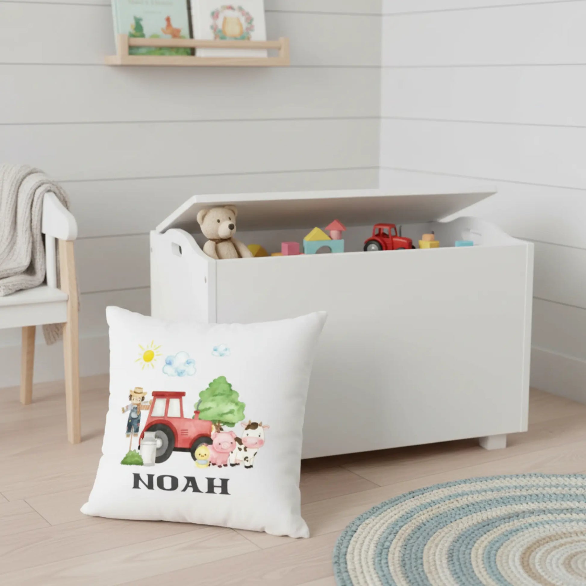 Personalised kids farm cushion with name beside a toy box 