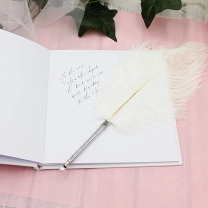 Beautiful white ostrich feather pen with blank ink for signing the register and guest book