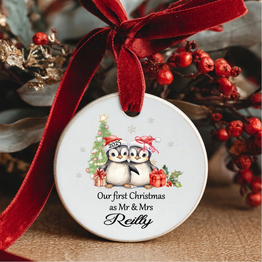 Personalised ceramic Christmas bauble with penguin couple and text “Our First Christmas as Mr & Mrs” – also available as Mr & Mr or Mrs & Mrs, handmade in Ireland.