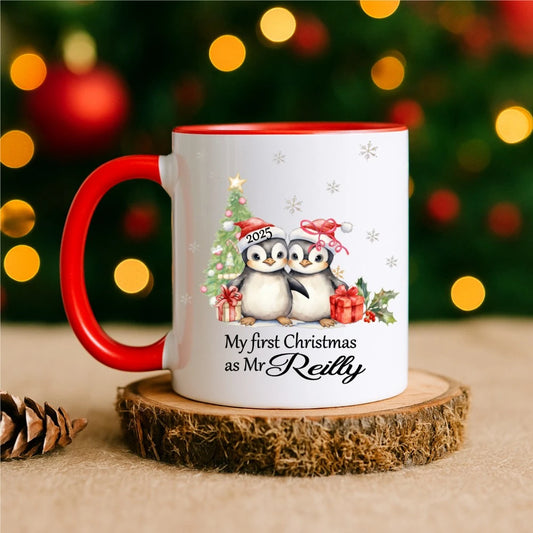 Mug with red handle reading “My First Christmas as Mr [Name]” with penguin couple illustration – personalised Christmas mug handmade in Ireland.