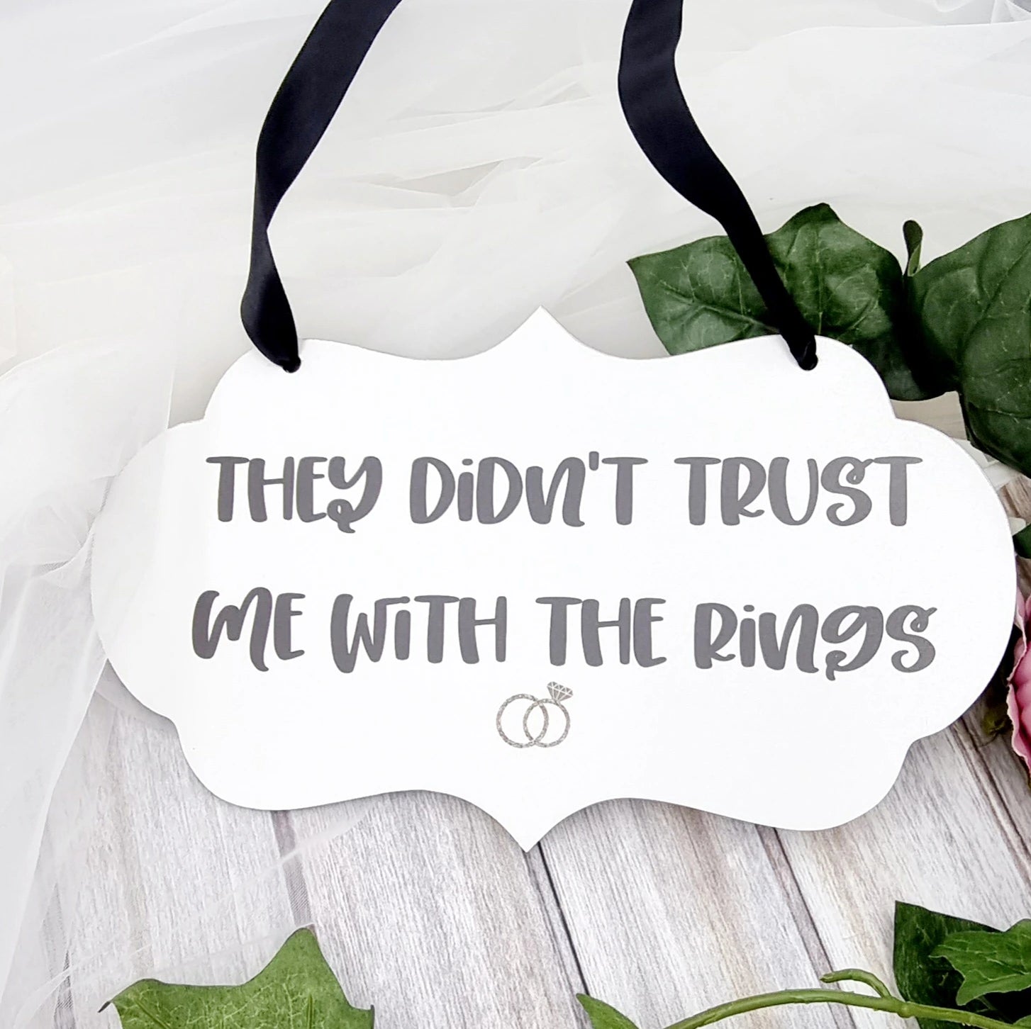 Page boy wedding sign with black ribbon reading “They didn't trust me with the rings”