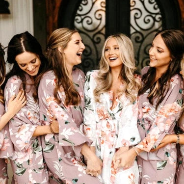 Bridal party wearing matching personalised floral robes in pink, blue and white – Irish made wedding morning robes