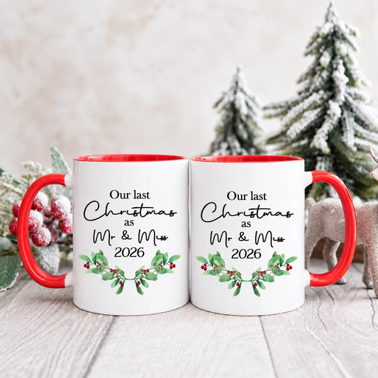 Personalised Our Last Christmas as Mr & Miss 2026 mug set with red handles, festive greenery and red berry design.