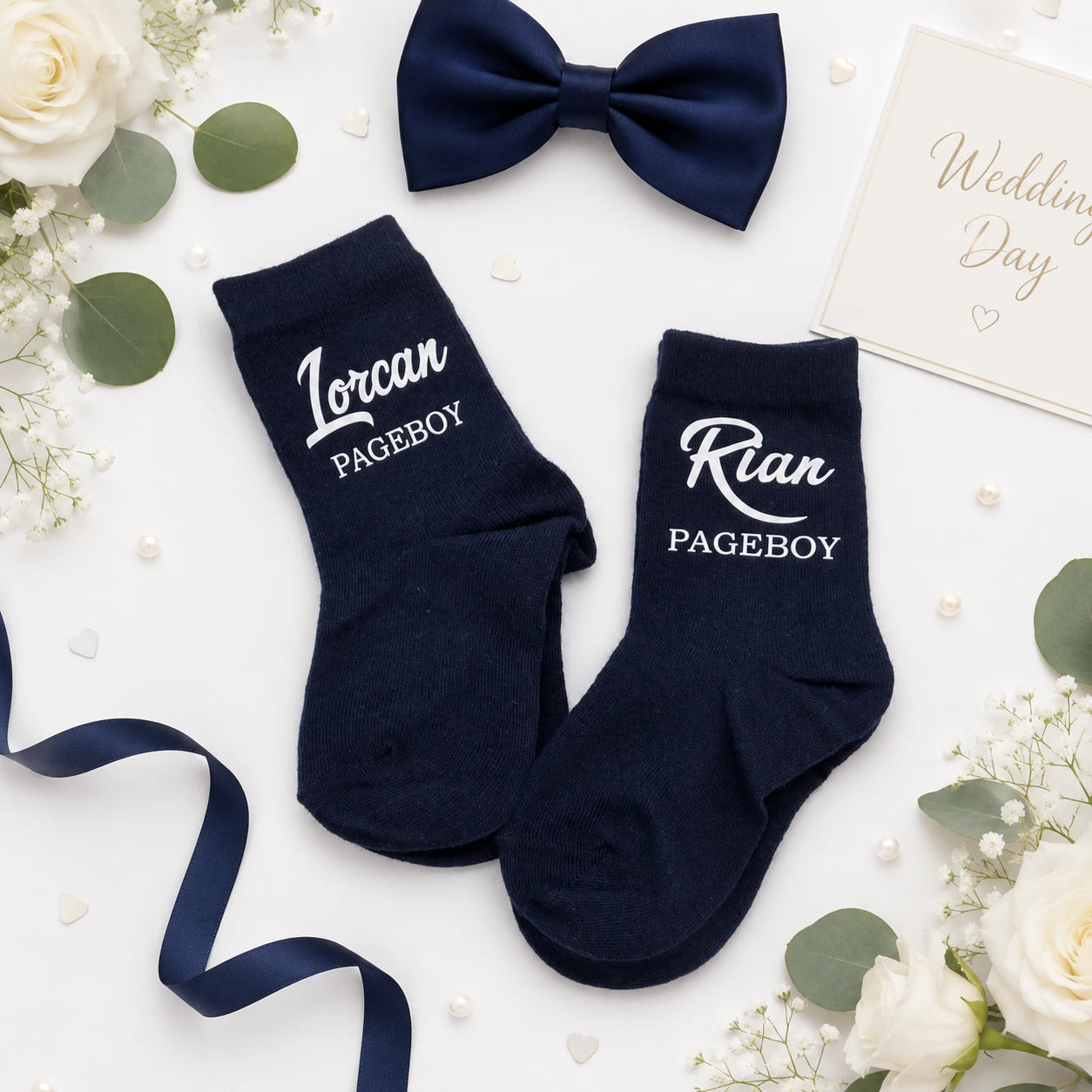 Two pairs of pageboy socks personalised with their name and title on a white background 