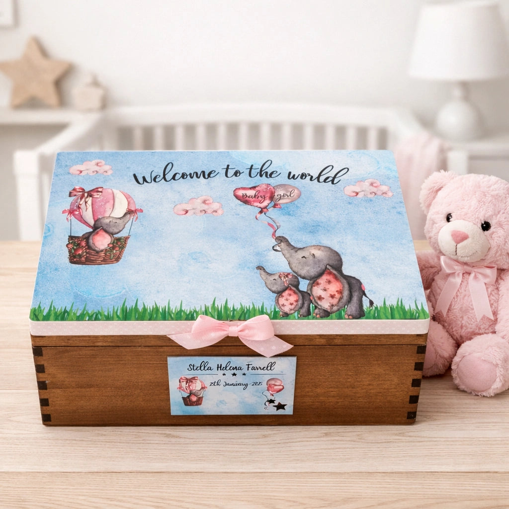 Personalised baby elephant keepsake memory box with ribbon sitting on a light wood table in a nursery beside a teddy bear, printed and finished in Co Meath Ireland.