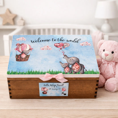 Personalised baby elephant keepsake memory box with ribbon sitting on a light wood table in a nursery beside a teddy bear, printed and finished in Co Meath Ireland.