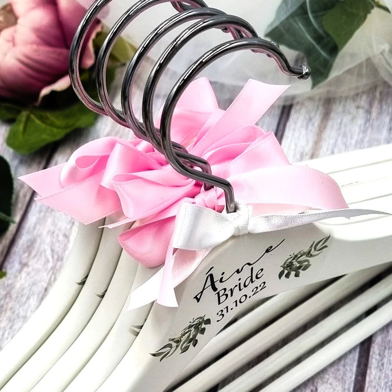 Close up of personalised bride hanger with pink ribbon showing custom name and wedding date