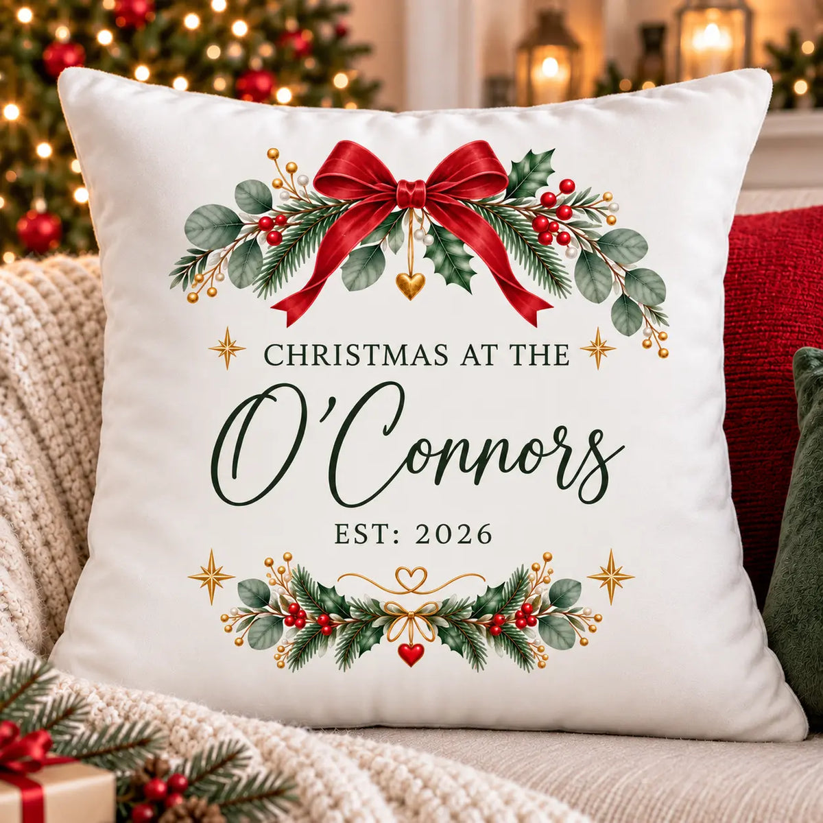 White velvet personalised Christmas cushion featuring Christmas at the Family Name, Est. 2026, with festive holly, red bow and gold details.