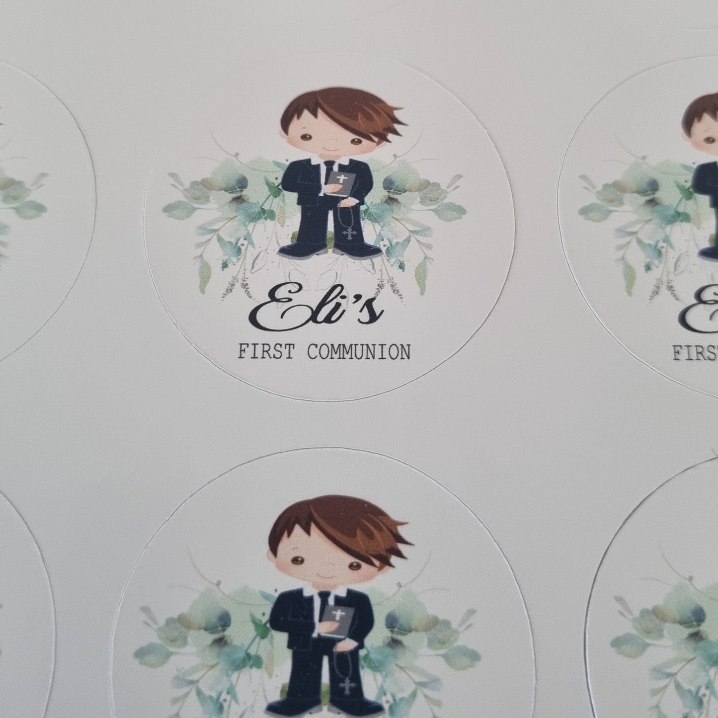Photo showing scale of personalised First Communion sticker sheets held in hand, custom name and date printed stickers