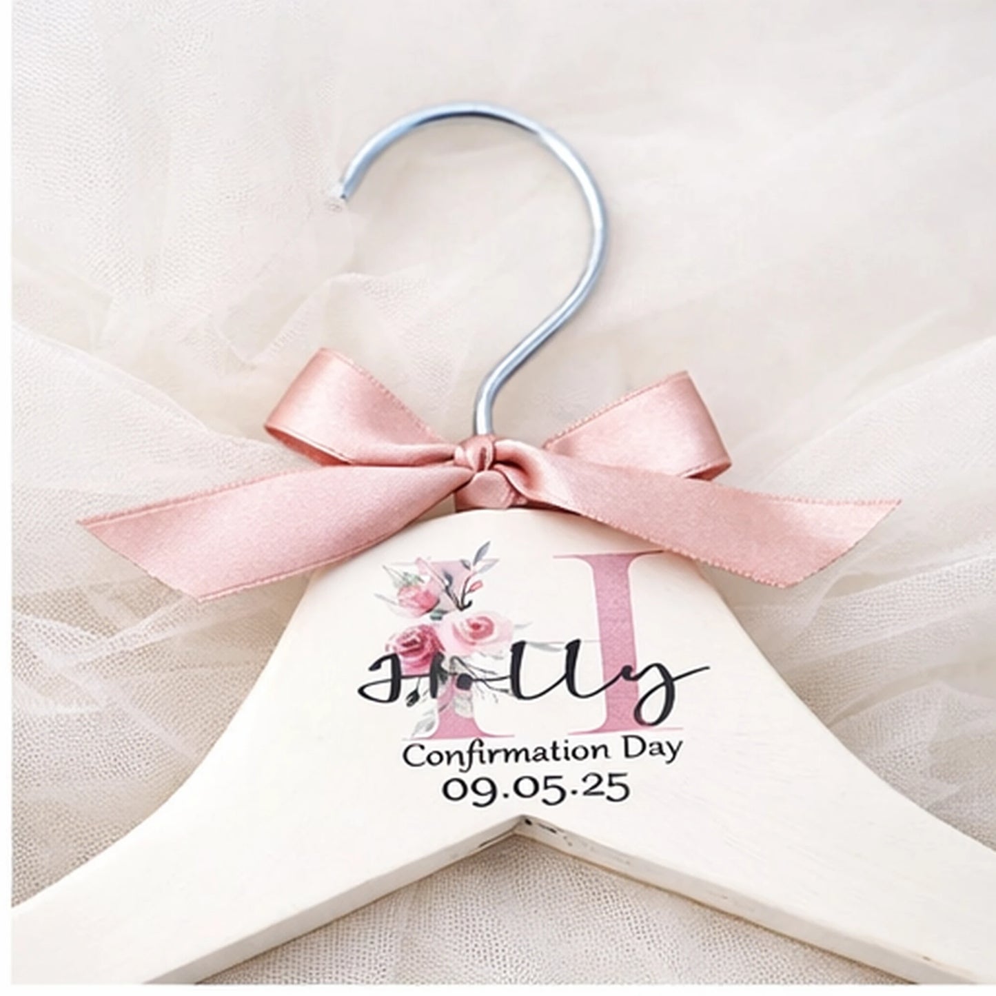 Close up of personalised confirmation dress hanger showing name, confirmation date and pink satin bow