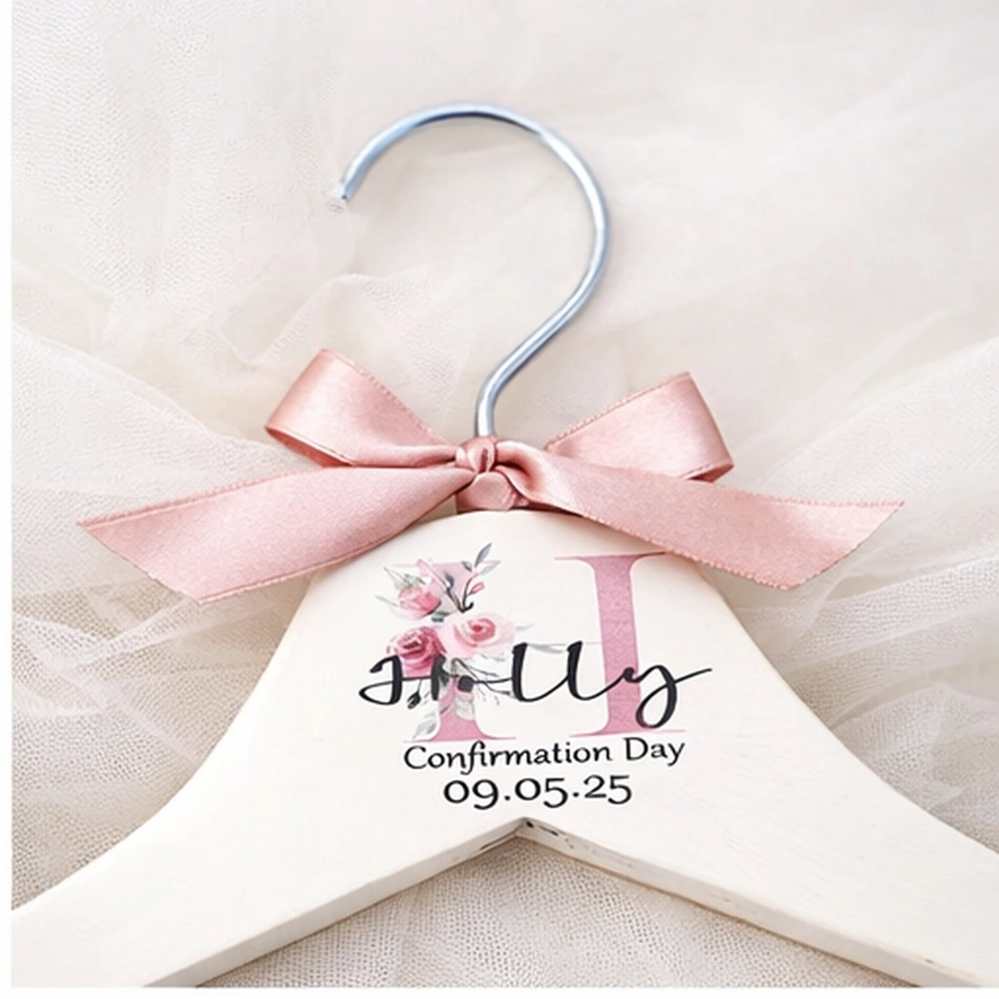 Close up of personalised confirmation dress hanger showing name, confirmation date and pink satin bow