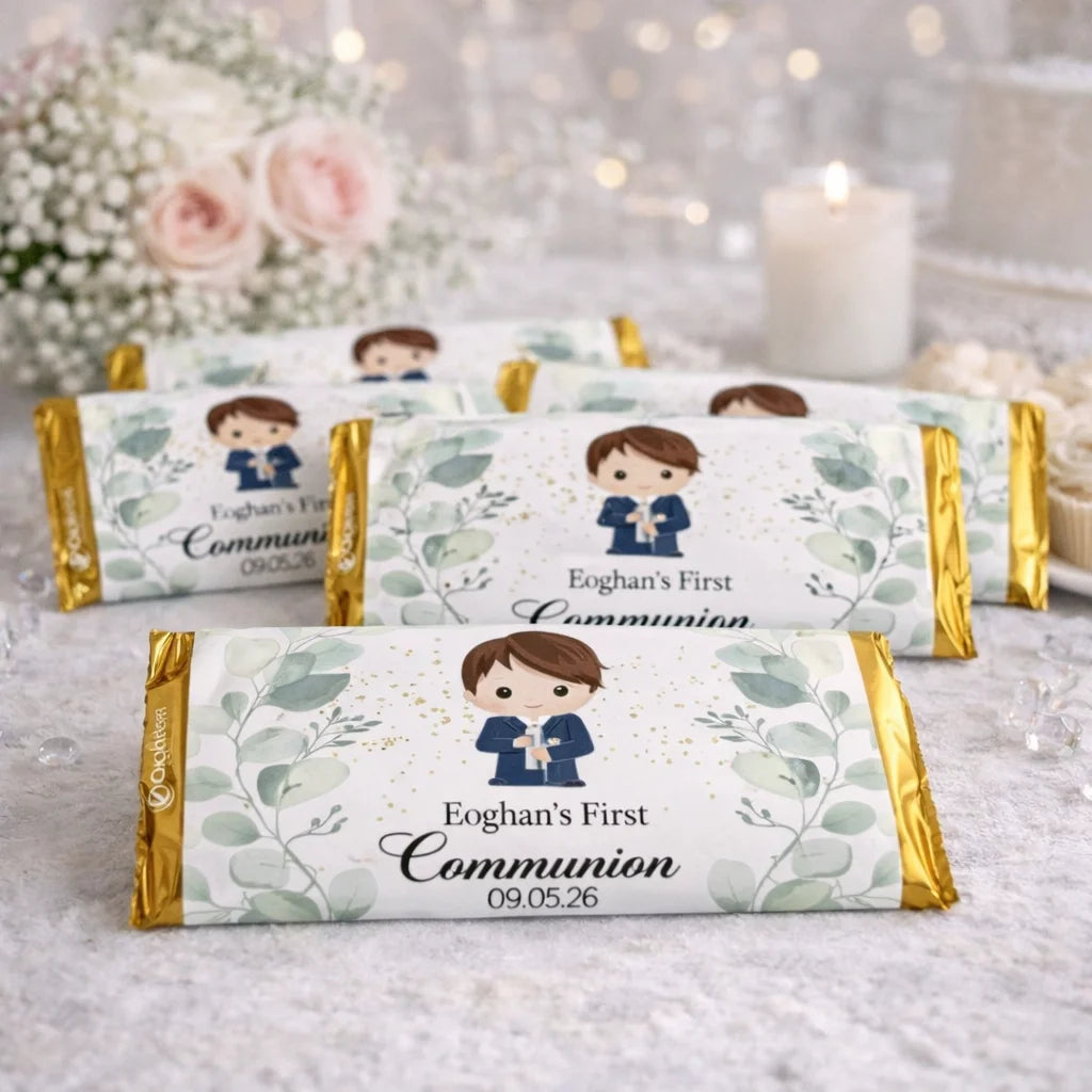 Personalised First Communion chocolate bar labels with gold wrapping, featuring a boy communion illustration and custom name and date, displayed on a First Communion party table.