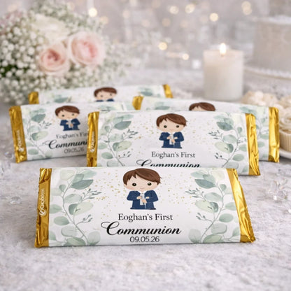 Personalised First Communion chocolate bar labels with gold wrapping, featuring a boy communion illustration and custom name and date, displayed on a First Communion party table.