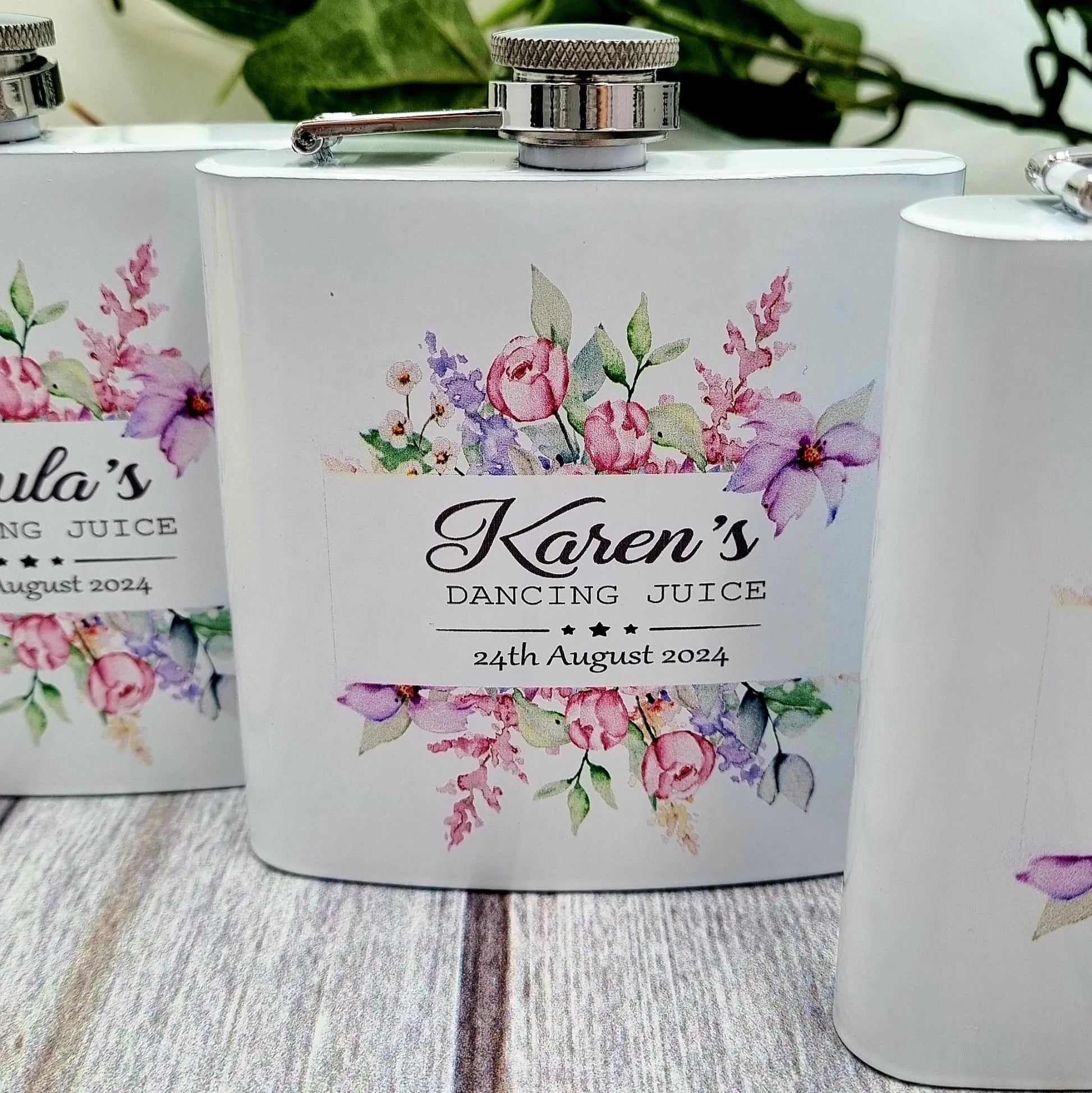 White personalised hip flask with floral watercolour design and custom name “Karen’s Dancing Juice” with wedding date, stainless steel lid, unique hen party and wedding gift Ireland.