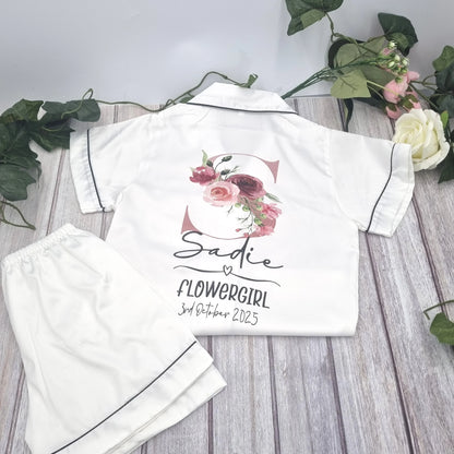 Personalised white satin flowergirl pyjamas featuring floral initial design with name and wedding date, printed and finished in Ireland by HanaLee Studios.