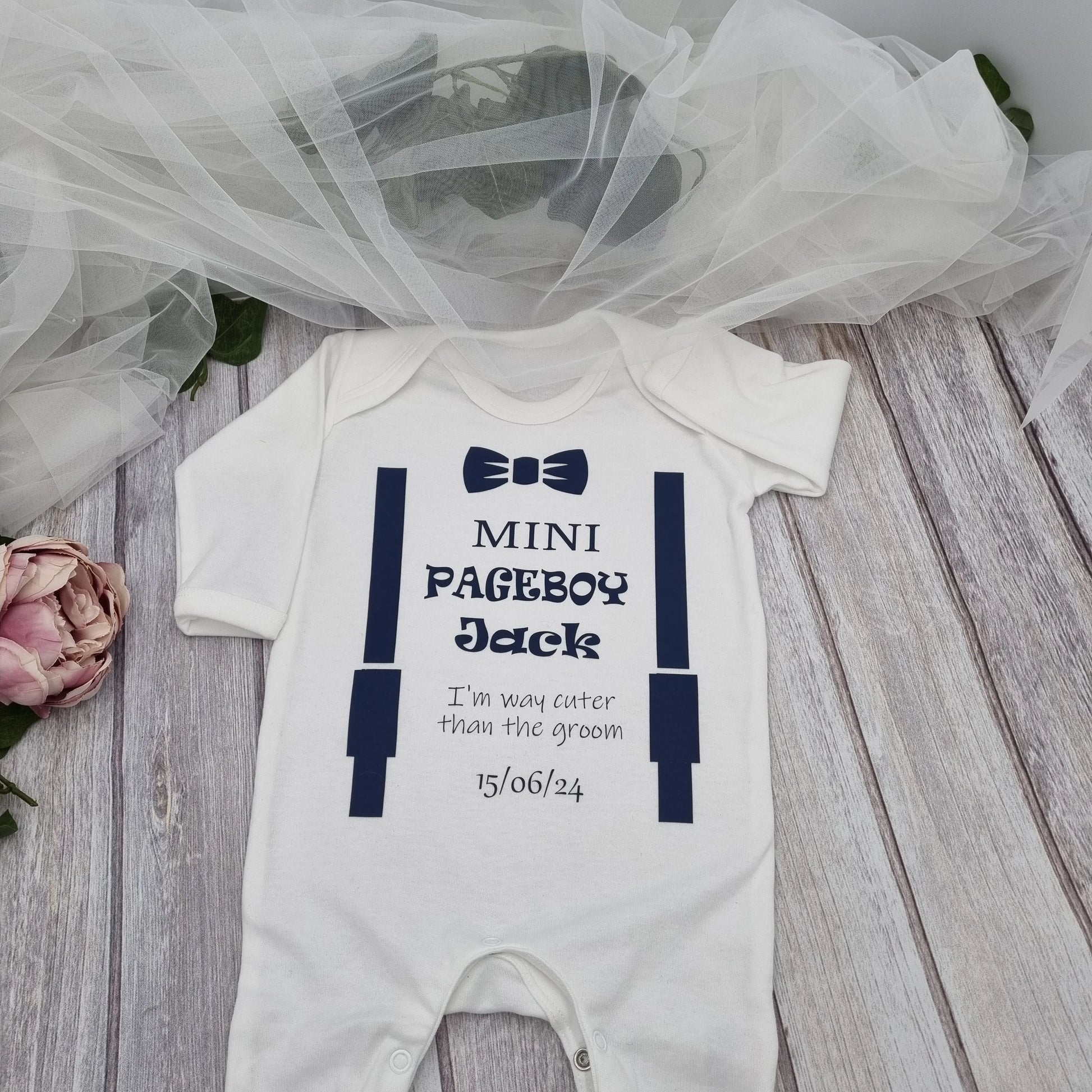 Personalised white Mini Pageboy babygro with navy braces and bow-tie print, customised with baby’s name and wedding date — printed and finished in Ireland by HanaLee Studios.