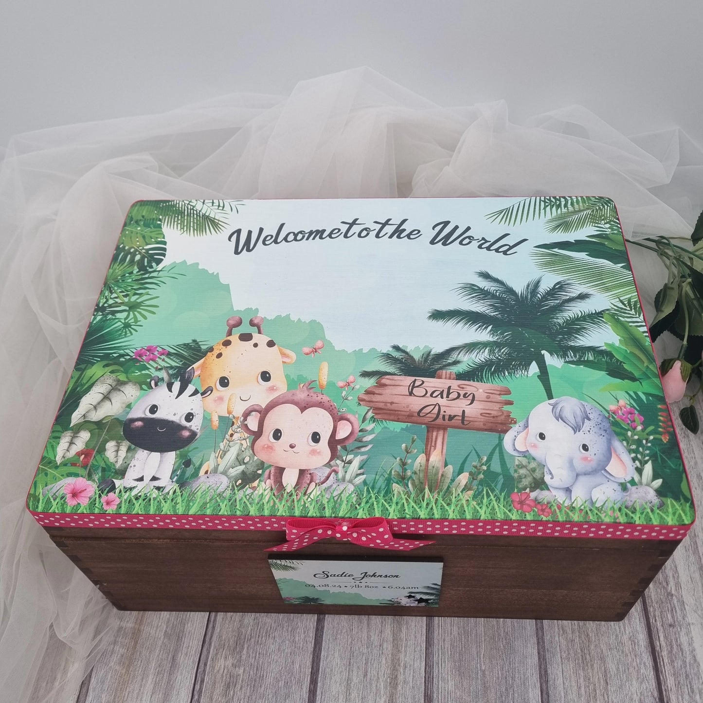 Personalised wooden baby keepsake box with safari animals design, pink ribbon trim and baby girl details on lid, perfect newborn memory chest gift.
