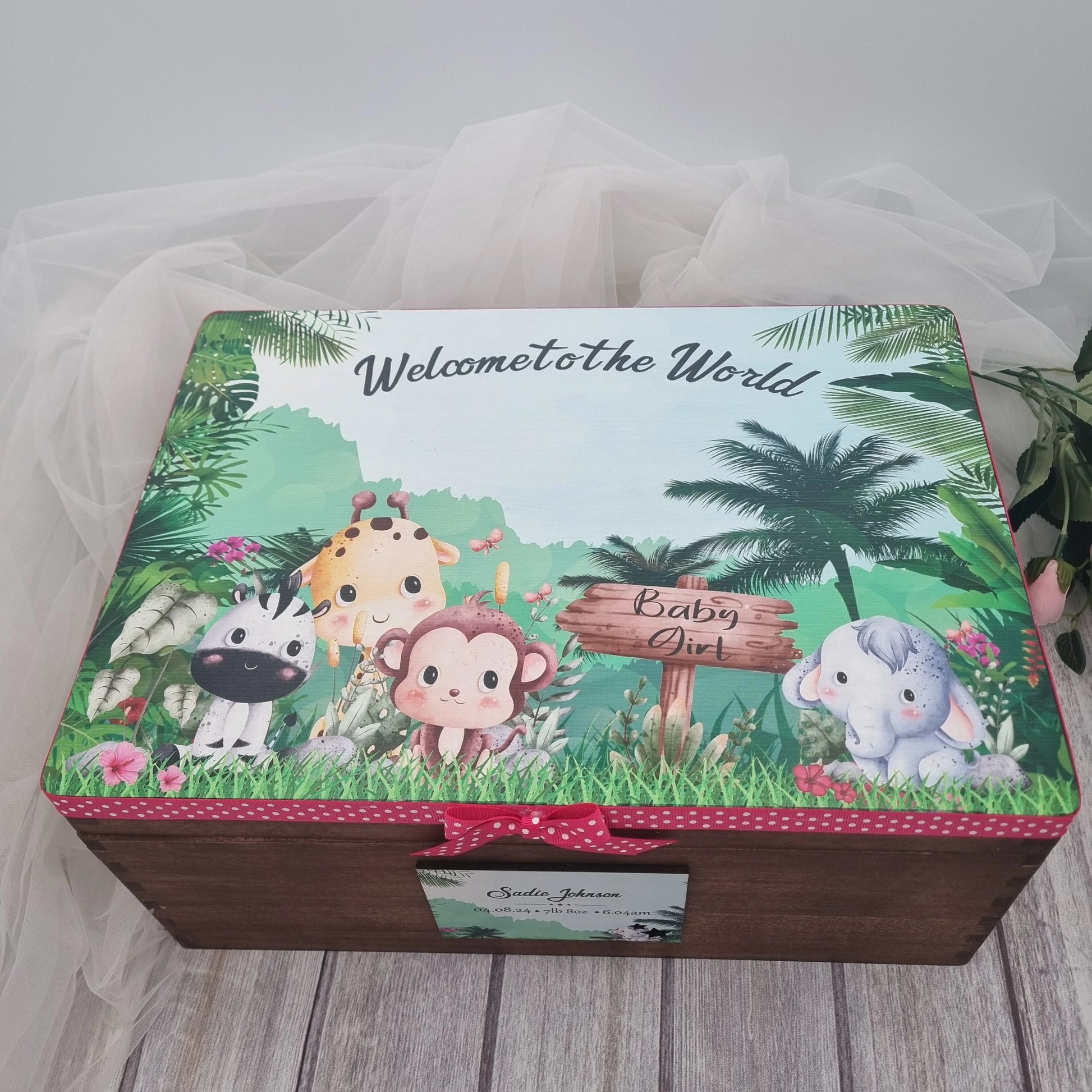 Personalised wooden baby keepsake box with safari animals design, pink ribbon trim and baby girl details on lid, perfect newborn memory chest gift.
