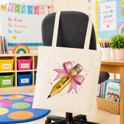 Personalised cream teacher tote bag with custom teacher name and pink pencil design in classroom setting