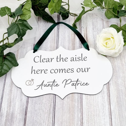 Flower girl or page boy wedding sign with green ribbon reading “Clear the aisle here comes our Auntie Patrice”