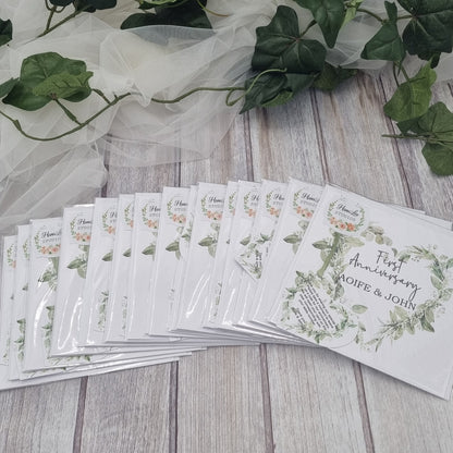 Set of personalised wedding anniversary table cards with eucalyptus greenery wreath design displayed on wooden table – Irish made wedding reception keepsake by HanaLee Studios