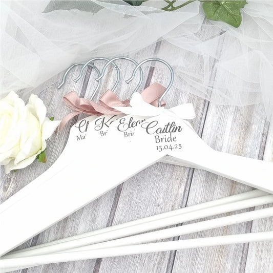 Personalised white wooden wedding hanger with name, title and date in black script, finished with blush pink ribbon – shipped from Ireland