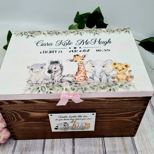 Personalised wooden baby keepsake box with safari animal design, customised with baby’s name, birth details, and finished with pink ribbon and bow