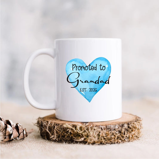 White ceramic mug with blue heart and the words Promoted to Grandad Est. 2026, personalised pregnancy reveal gift for new grandparents, Irish handmade.