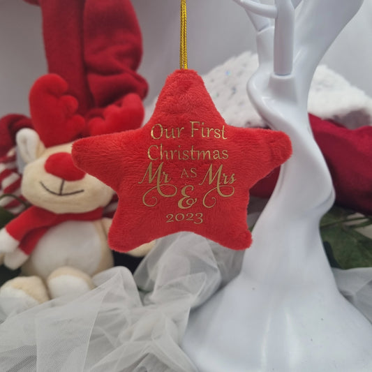 Red star ornament with 'Our First Christmas Mr & Mrs & 2023' text, surrounded by festive decorations.