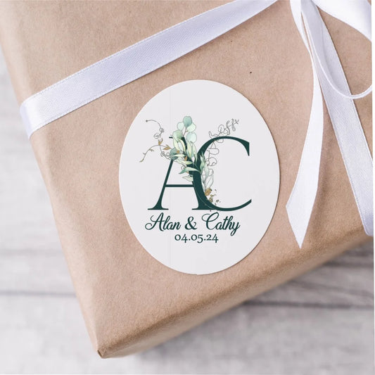 Customised wedding stickers with dark green initials of the couple, their names underneath and wedding date. 