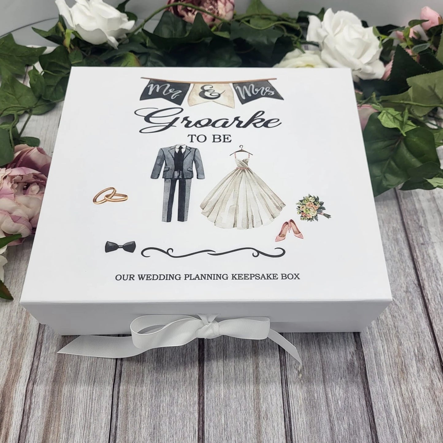 White personalised wedding planning keepsake box featuring bride and groom illustrations and “Mr & Mrs To Be” banner, tied with a white ribbon.