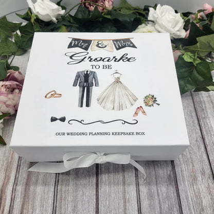 White personalised wedding planning keepsake box featuring bride and groom illustrations and “Mr & Mrs To Be” banner, tied with a white ribbon.
