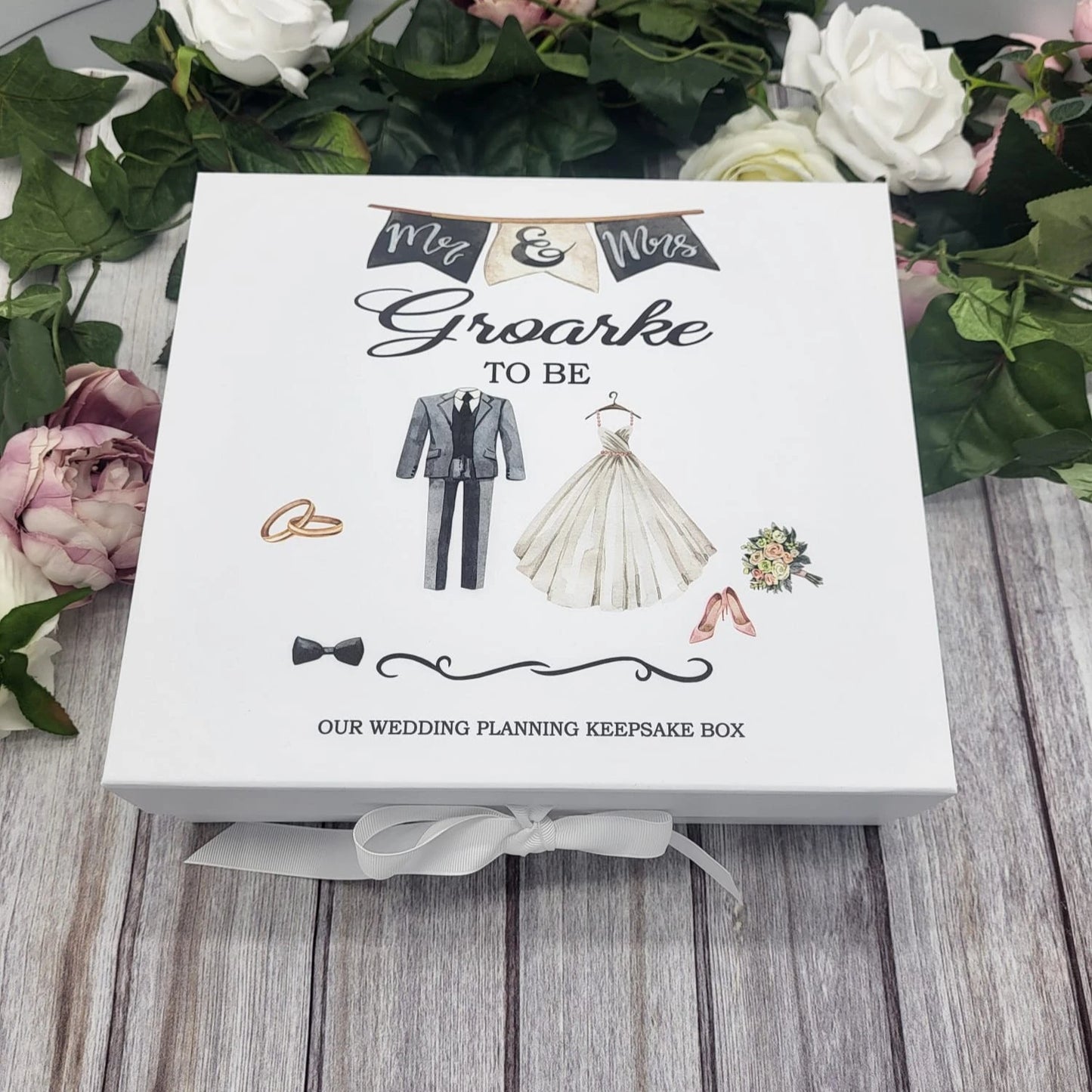 White personalised wedding planning keepsake box featuring bride and groom illustrations and “Mr & Mrs To Be” banner, tied with a white ribbon.
